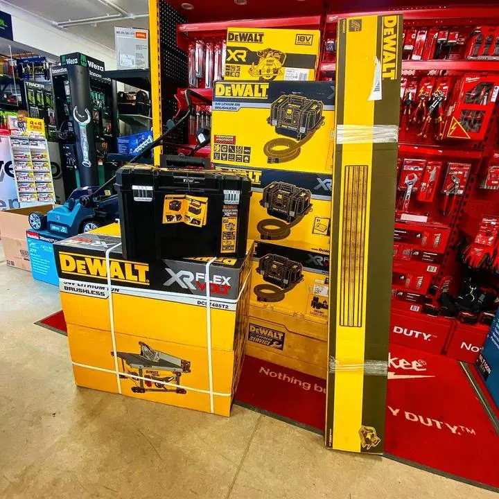 Stacked DeWalt FlexVolt tool boxes and a table saw on the shop floor